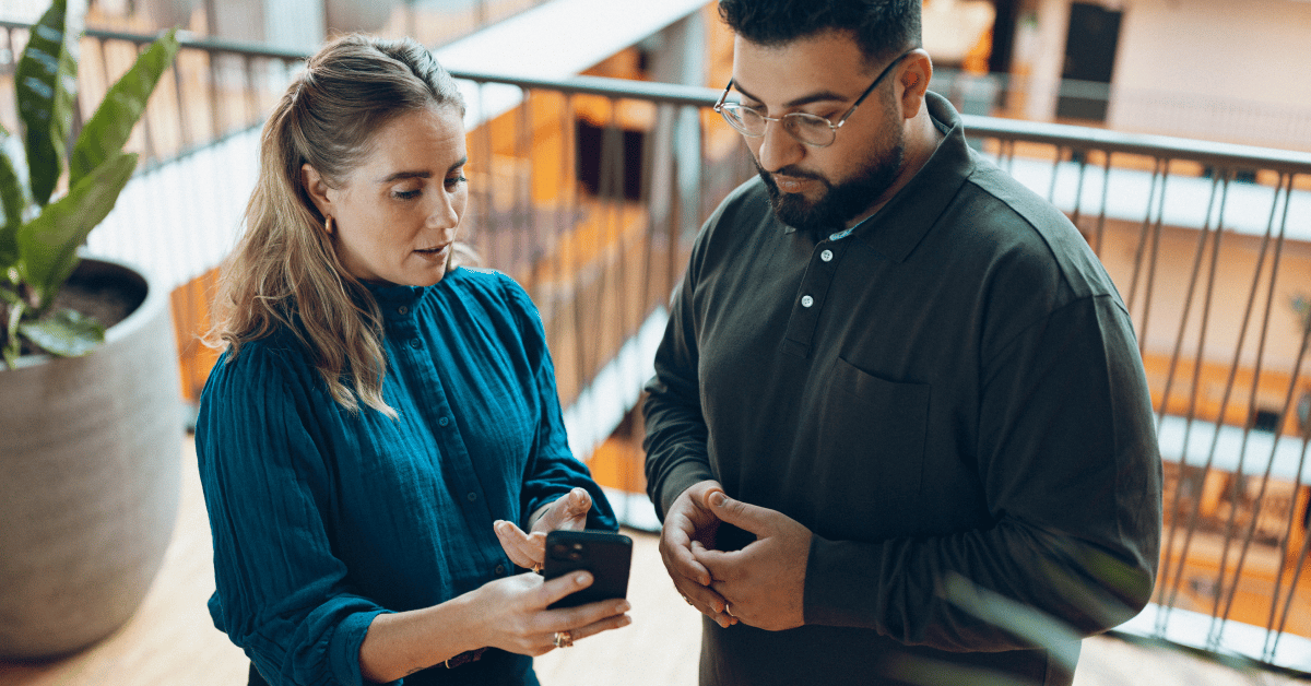 absence-registration-two-colleagues-looking-at-iphone